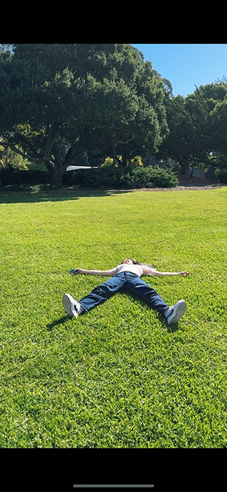 Photo of Dan Zhao lying on the grass