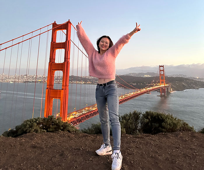 Jeongseo Kim stands in front of the Golden Gate Bridge