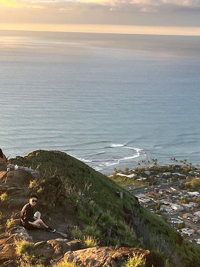 Keyang Pan sits on a hillside overlooking the Pacific Ocean