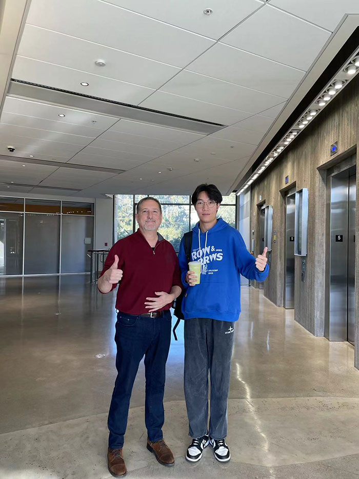 Zhong Li and a professor take a photo inside a UC Berkeley building