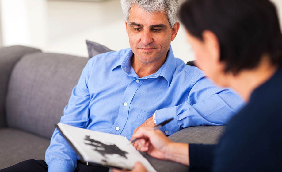 Older patient talking to counselor with a Rorschact test