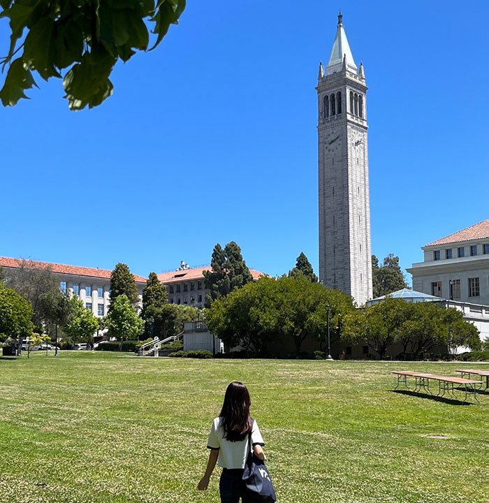 Jeongseo Kim on campus at Memorial Glade with Campanile in background