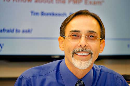 Panelist Edmond Matevosian wearing a blue shirt in front of a powerpoint screen