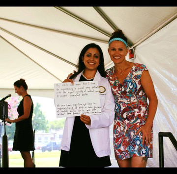 Ilse Tejeda holding up a handwritten sign at graduation