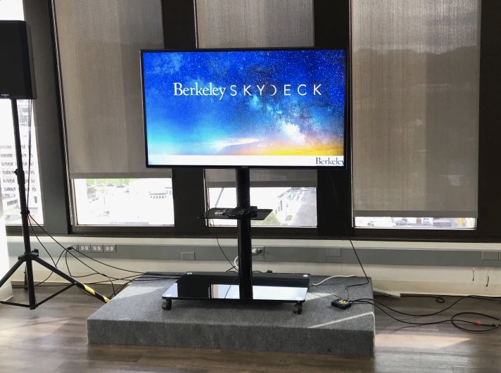 A large monitor with the Berkeley Skydesk logo projected on it. 