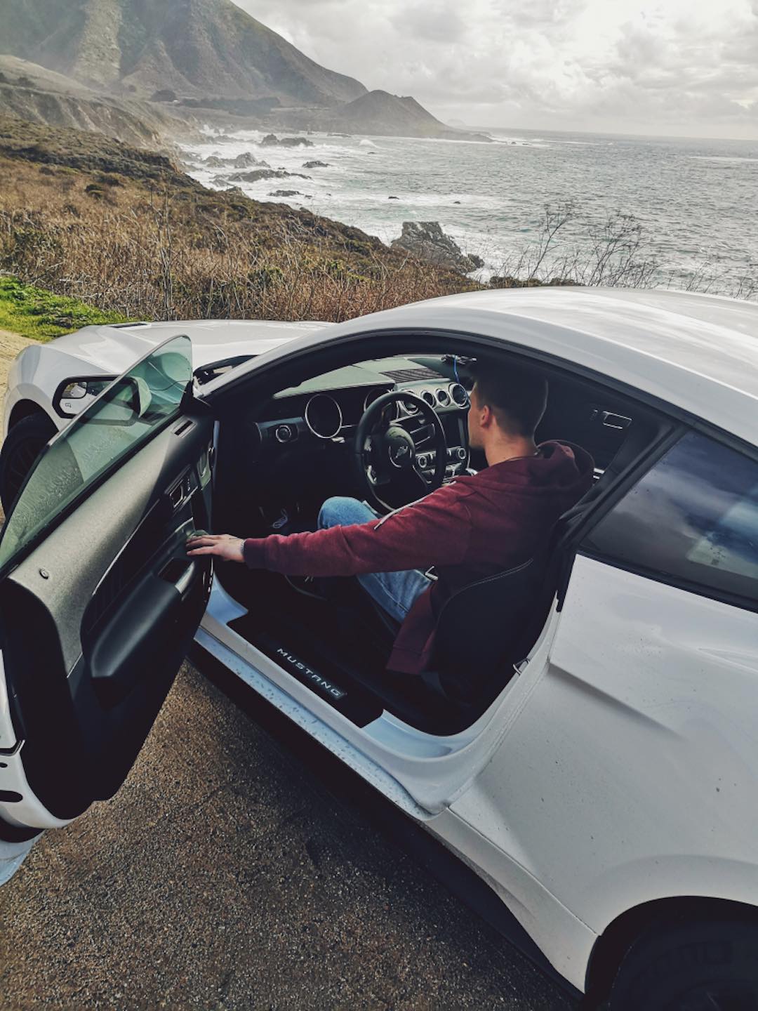 Markus sitting in the brand new 5.0 Mustang GT while looking out at the ocean