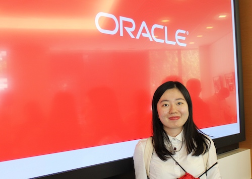 UC Berkeley Extension student in front of Oracle sign during a visit to the company.