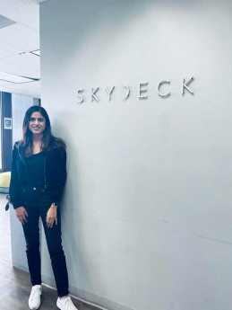 Meru Sharma standing in front of Skydeck logo