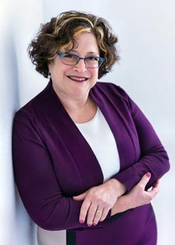 Susan Schwartz leans against a white wall