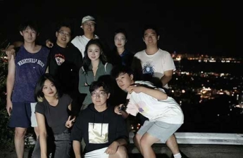 Dan Zhu and friends take group photo in front of cityscape