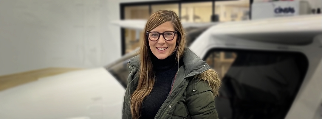 Professional Sequence in Editing graduate Megan Rupert, in front of small aircraft