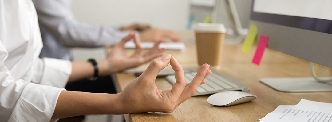 Hands of employee at the work place in meditative posture