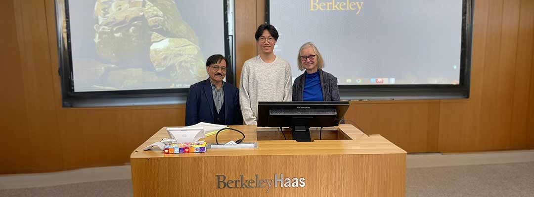 Zhong Li standing with Berkeley Haas professors inside at classroomm