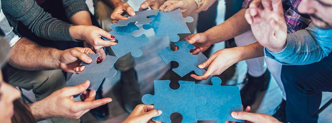Group of diverse professionals holding jigsaw puzzle pieces