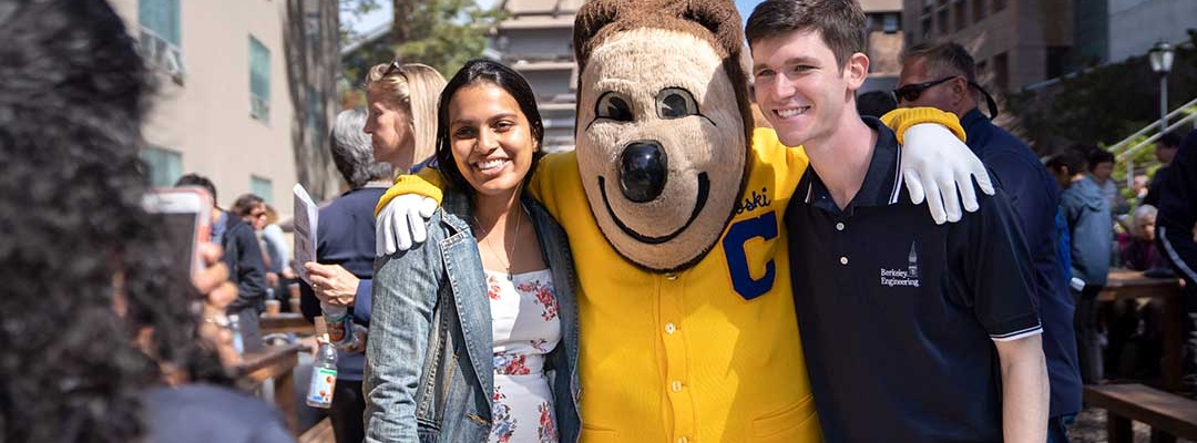 Two Berkeley students posing with Oski Bear in front of the camera