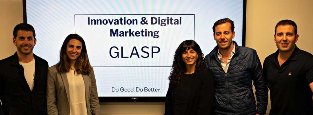 Custom programs students standing in front of digital display of their GLASP marketing presentation
