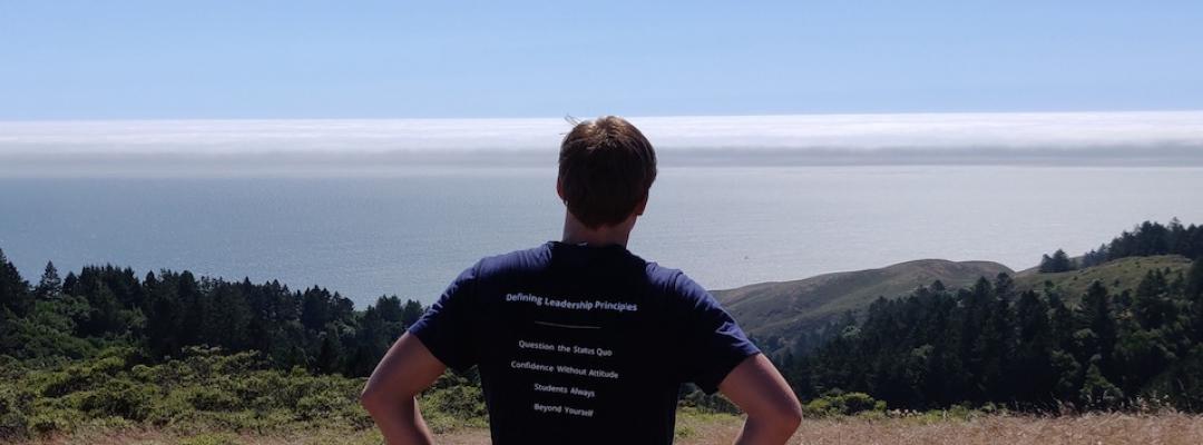 BHGAP student Hugo wears his Haas School of Business t-shirt and looks out over a view of Berkeley