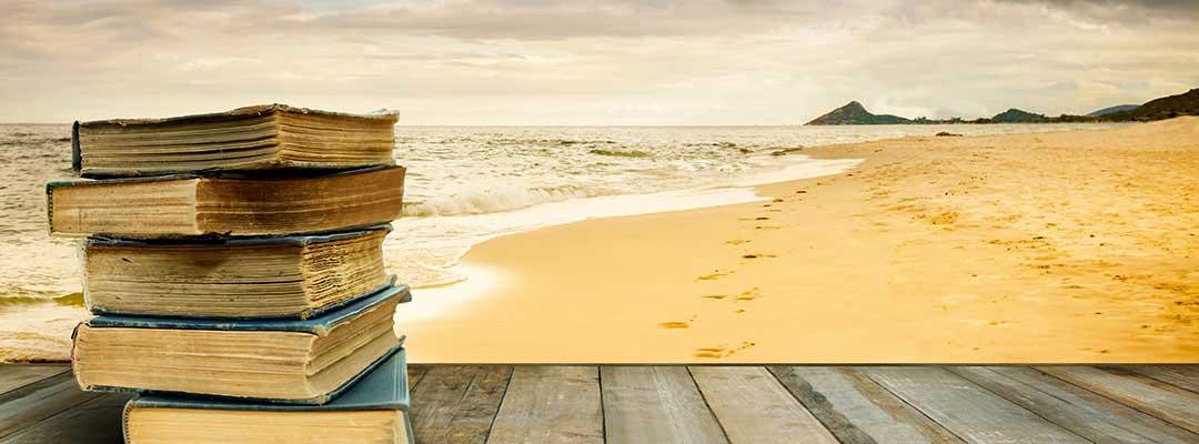 Stack of books on a wood platform on a beach