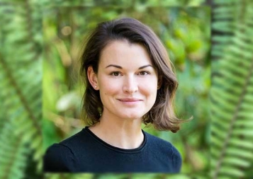 Headshot of Kseniya Norkina in front of foliage background