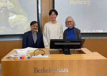 Zhong Li standing with Berkeley Haas professors inside at classroomm