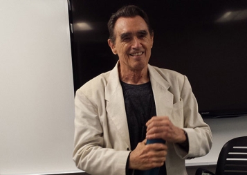 Writing instructor and poet Clive Matson standing in the front of a classroom at UC Berkeley Extension in San Francisco