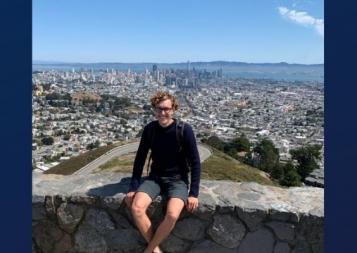 BHGAP student Frederic Bock visits San Francisco's Twin Peaks and poses in front of a view of the city