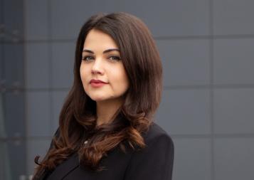 Photo of UX Design program graduate Iliyana Bozhanina in front of a dark gray building