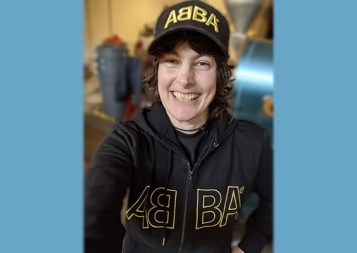 Photo of Jen St. Hilaire wearing ABBA sweatshirt and hat