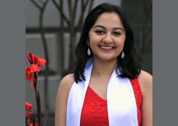 Post-Baccalaureate Program for Counseling and Pyschology Professions graduate Karishma Bajaj outside in front of red flower