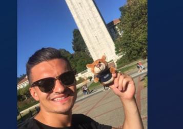 Lukas poses in front of UC Berkeley's campanille with a stuffed Oski Bear