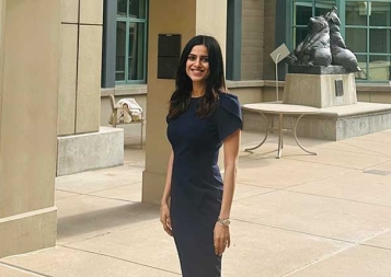 Meru Sharma wearing a black dress standing in front of Berkeley Haas building