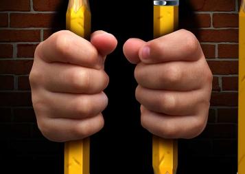 Photo of person in jail with pencils as the jail bars