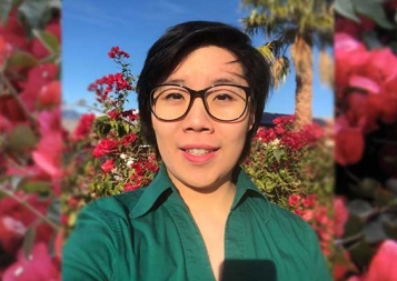 Photo of Robin Duong in front of a rose bush