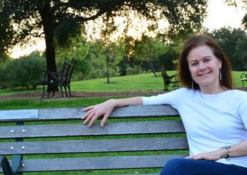 Editing program graduate Stephanie Martch sitting on a park bench in Texas