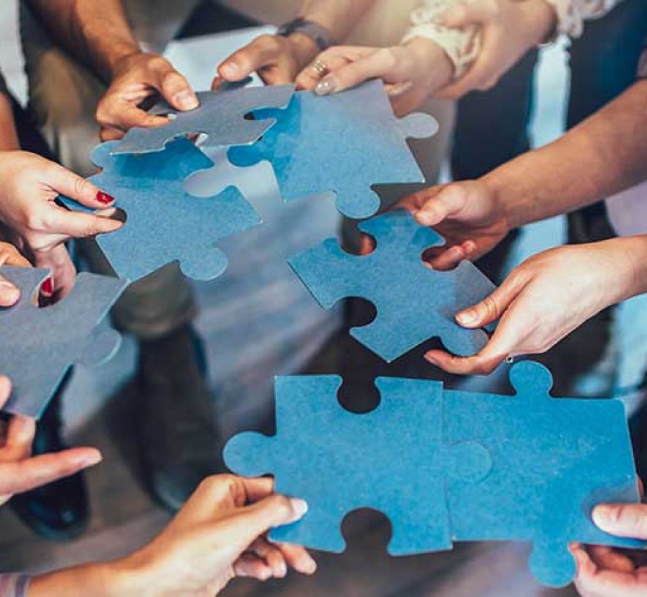 Group of diverse professionals holding jigsaw puzzle pieces