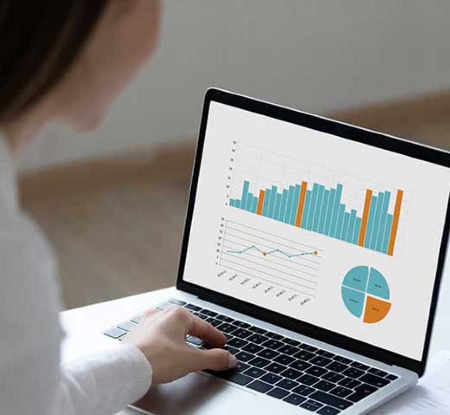 Woman working on laptop displaying business graphs