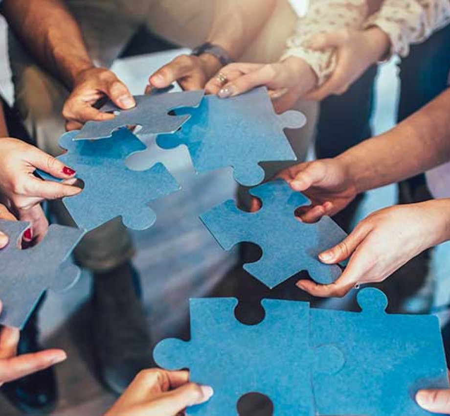 Photo of hands holding pieces of a jigsaw puzzle