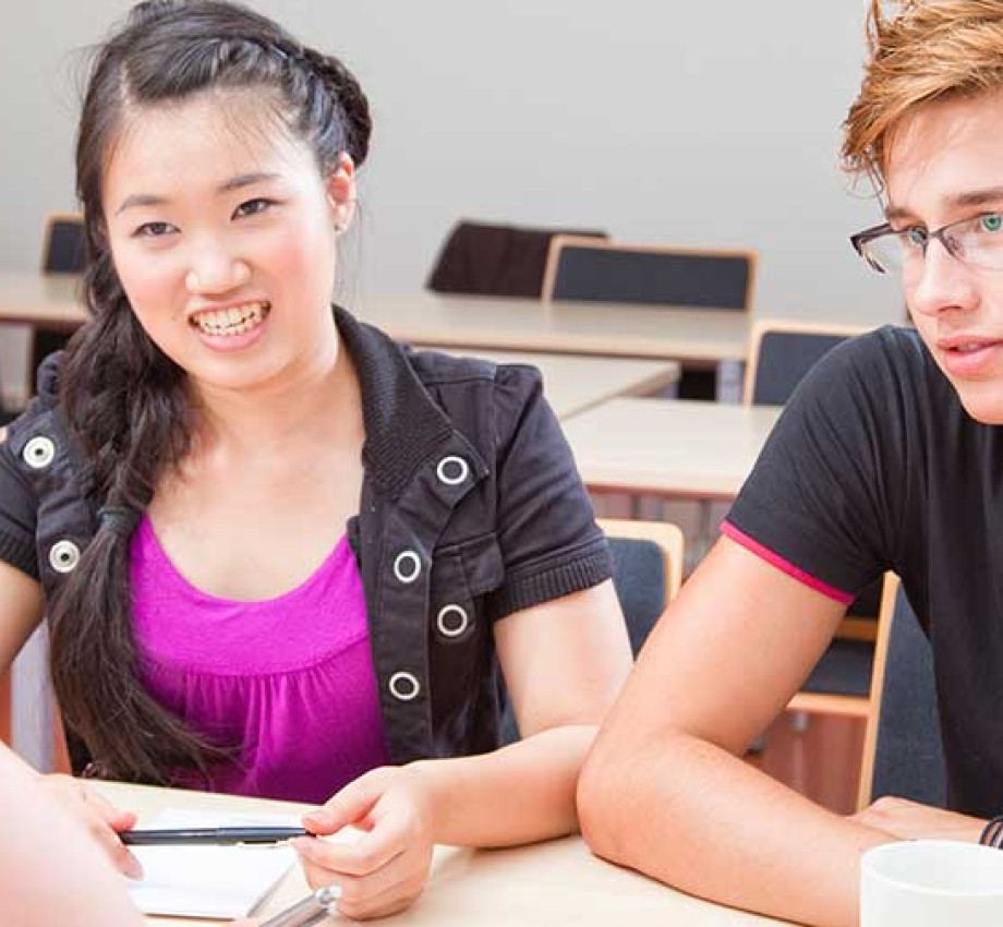 Photo of educational consultant working with two high school students