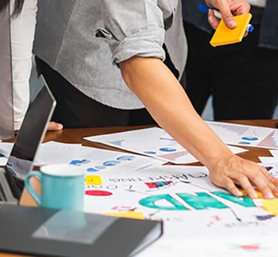 Photo of group of marketing professionals working on branding documents and sticky notes