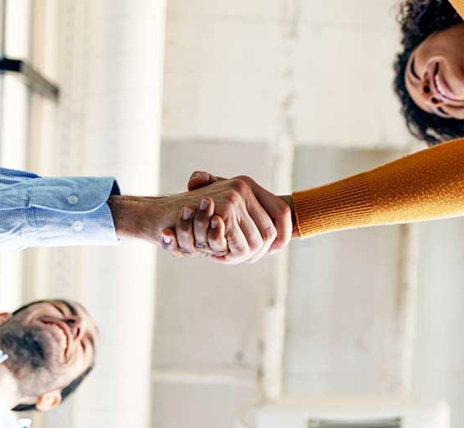 Photo looking up of two people shaking hands