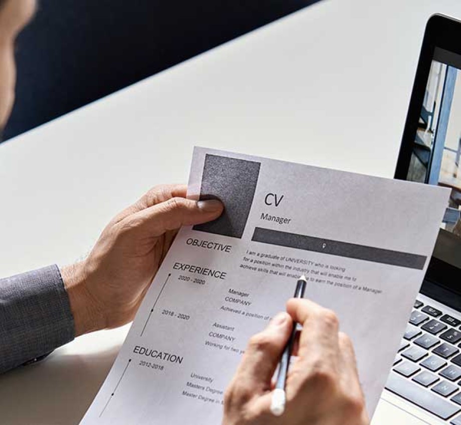 Male professional looking at CV with job applicant on a teleconferencing call