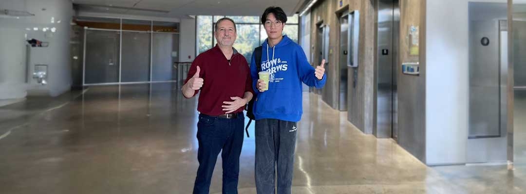 Zhong Li and a Berkeley faculty member giving the camera a thumbs-up in a building hallway