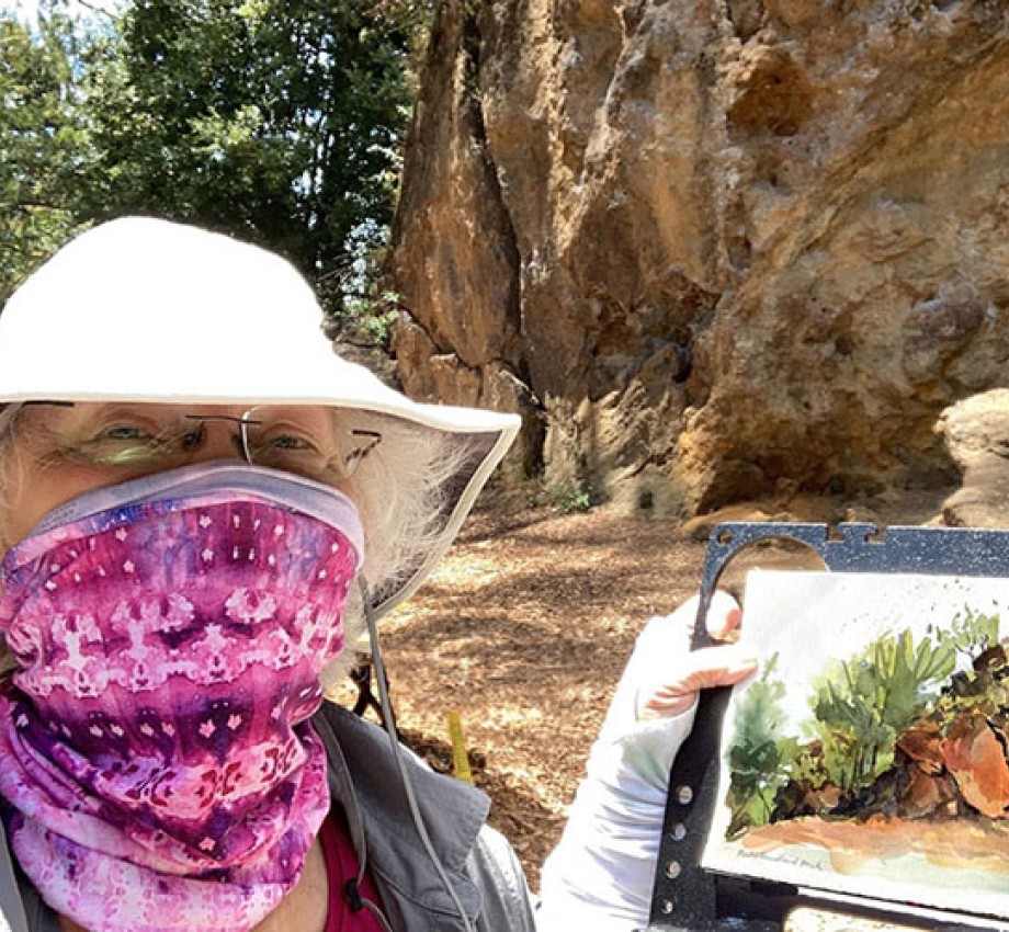 Jennifer Mahoney wearing a face mask while holding recent painting