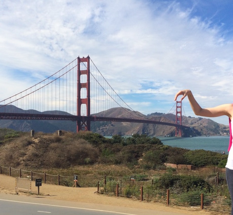 Graduate Maria Paula poses playfully in front of the Golden Gate bridge