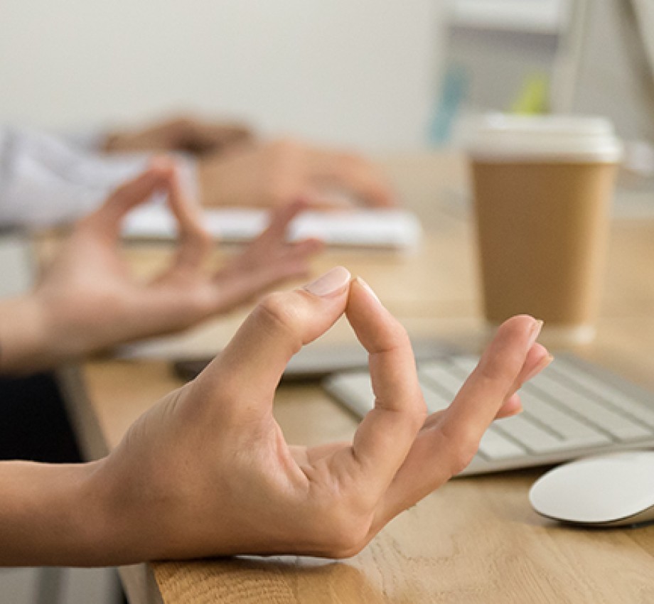 Hands of employee at the work place in meditative posture