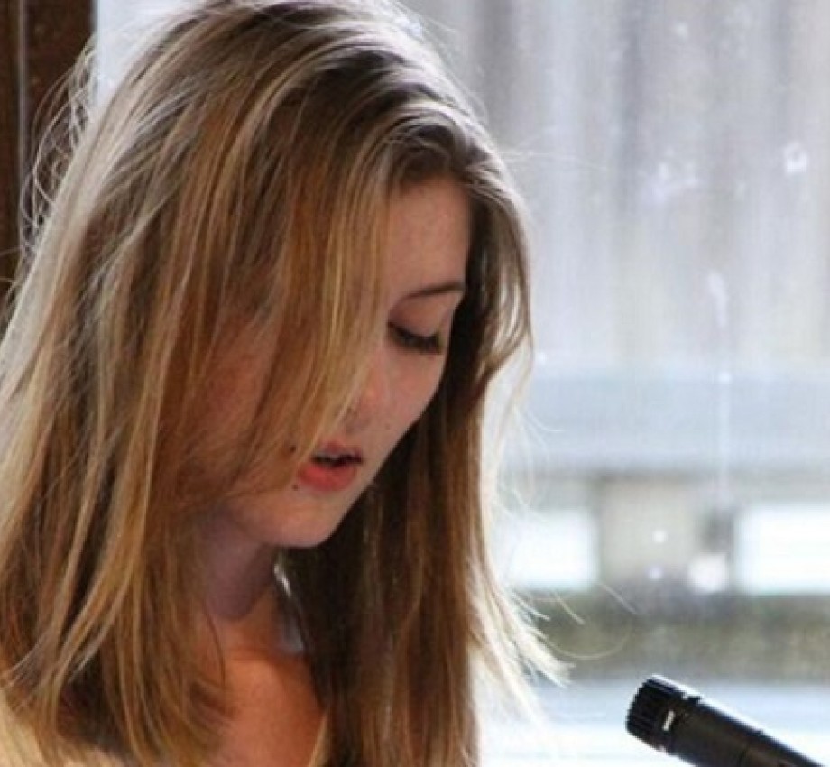 Professional Writing Community Impact Scholarship winner Adelle Brunstad reading her work at an event. Photo.