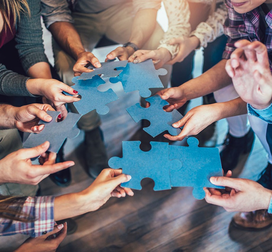 Photo of people holding blue pieces of a puzzle