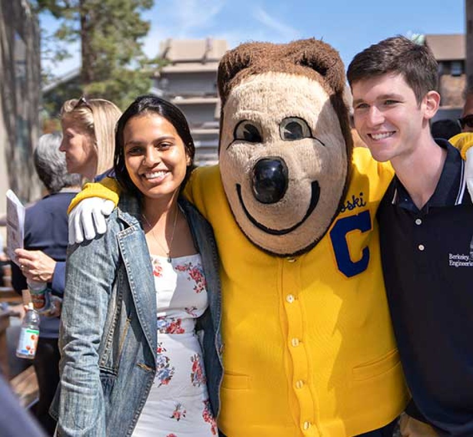 Two Berkeley students posing with Oski Bear in front of the camera