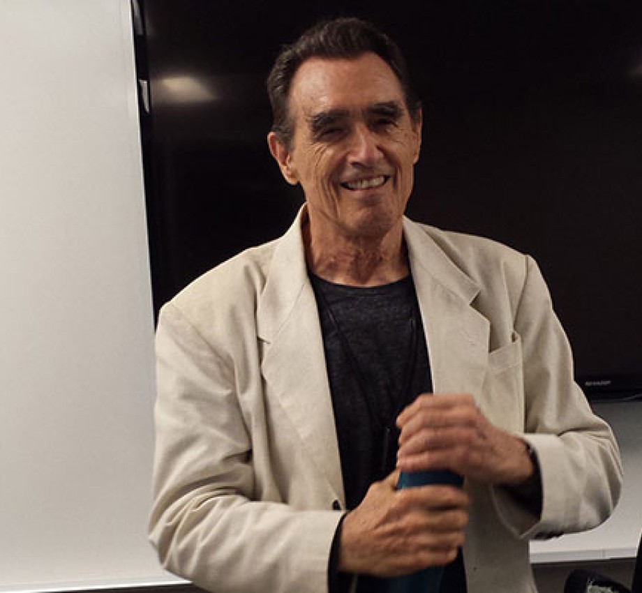 Writing instructor and poet Clive Matson standing in the front of a classroom at UC Berkeley Extension in San Francisco