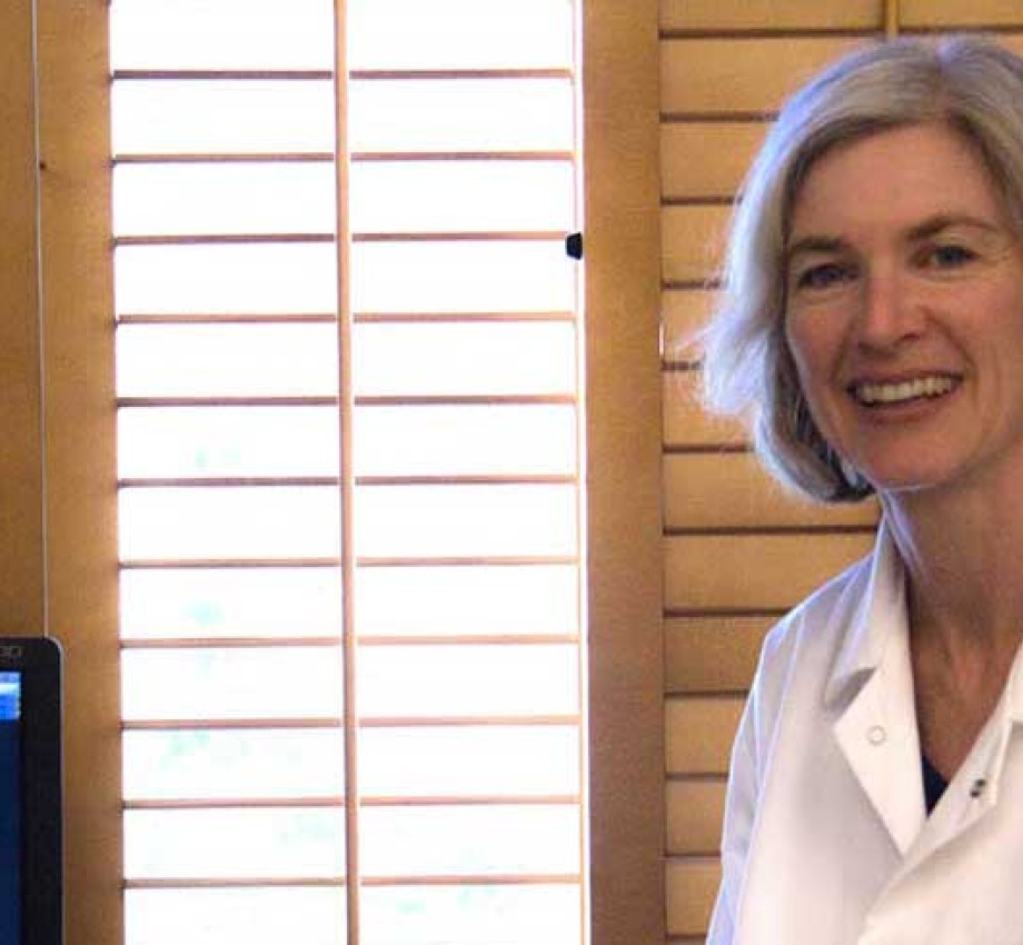 Photo of Jennifer Doudna next to a computer screen showing genome